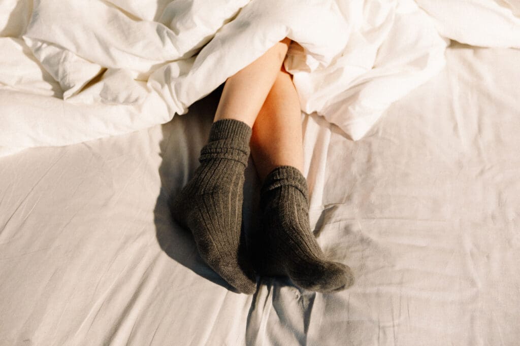 Feet in grey socks on an unmade bed, a slow day when the content plan gets skipped again