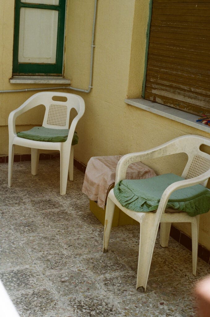 Two near-identical white plastic chairs on a patio, like copies of the same viral Instagram trend