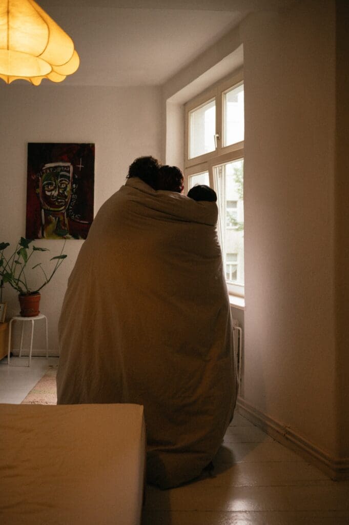 Person wrapped in a blanket in a bright room, avoiding a content plan that doesn't fit their life