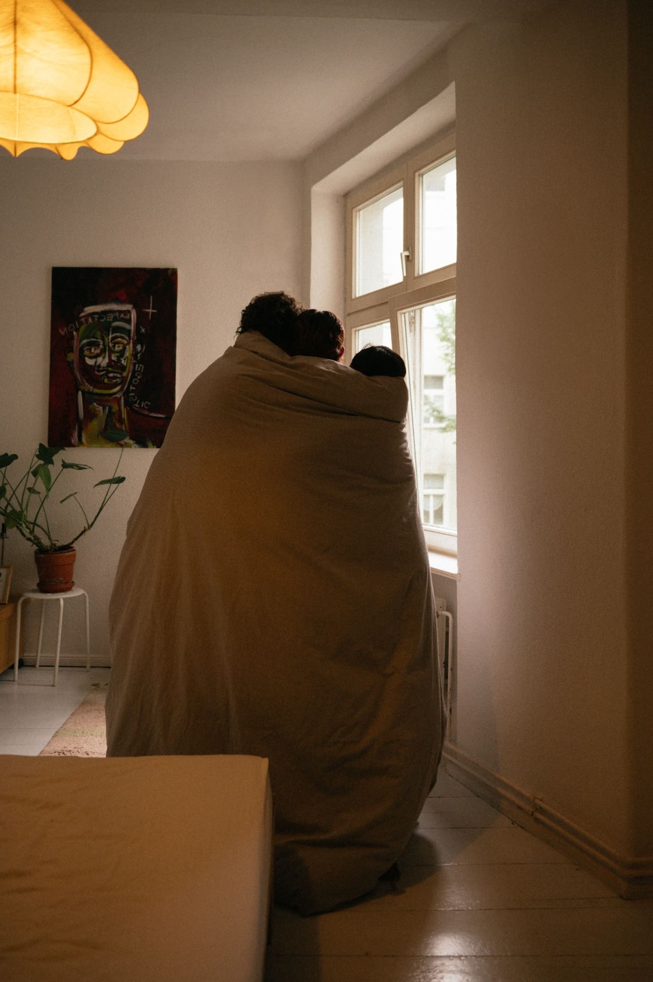 Person wrapped in a blanket in a bright room, avoiding a content plan that doesn't fit their life