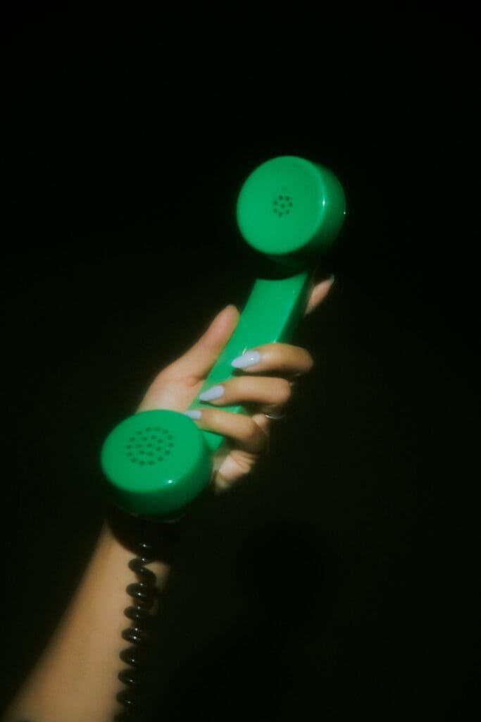Hand holding a green phone receiver, the moment someone shares an Instagram post with a friend